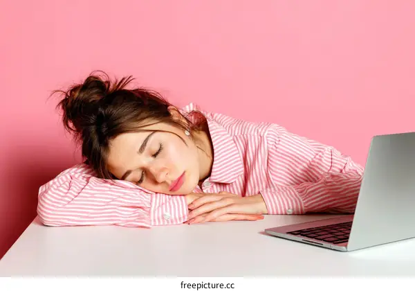 Tired Woman Sleeping on Desk with Laptop