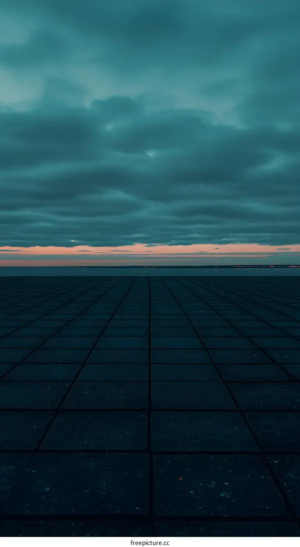 Dark Clouds Over A City Skyline At Dusk