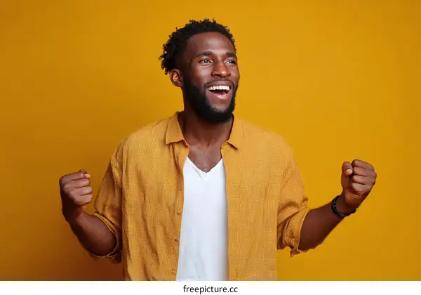 Happy Black Man Celebrating Success Against Yellow Background
