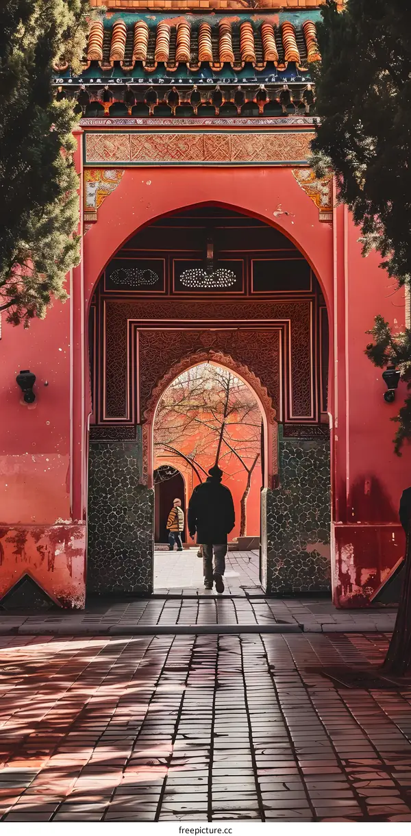 Man Walking Through Red Archway in Chinese Temple
