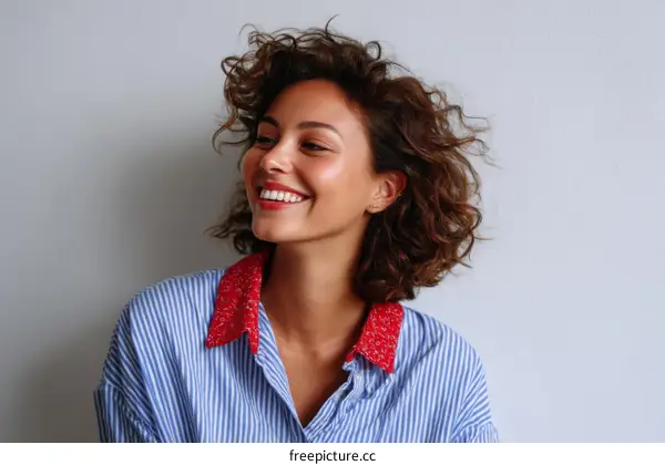 Smiling Woman with Curly Hair in Blue Striped Shirt