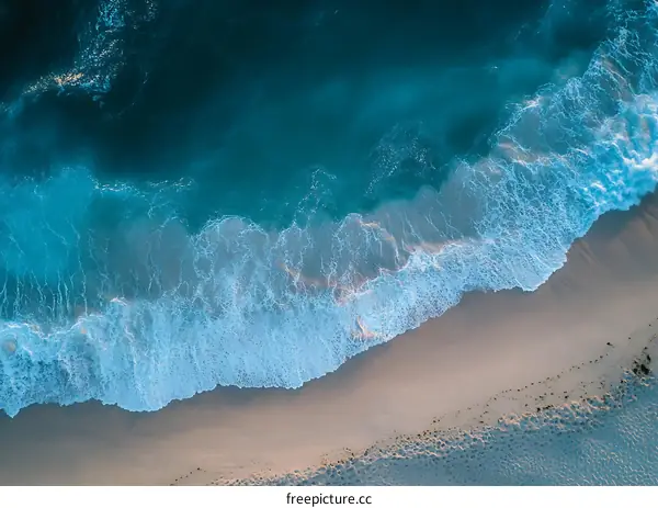 Aerial View of Ocean Waves Crashing on Sandy Beach