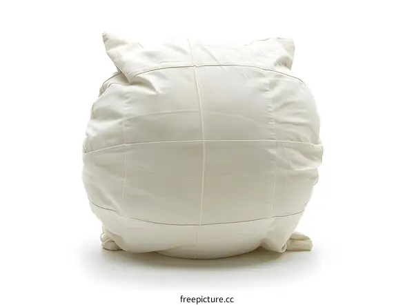 A large white pillow is placed on the ground against a white background.