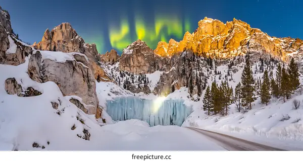 Frozen Waterfall in the Mountains with Northern Lights