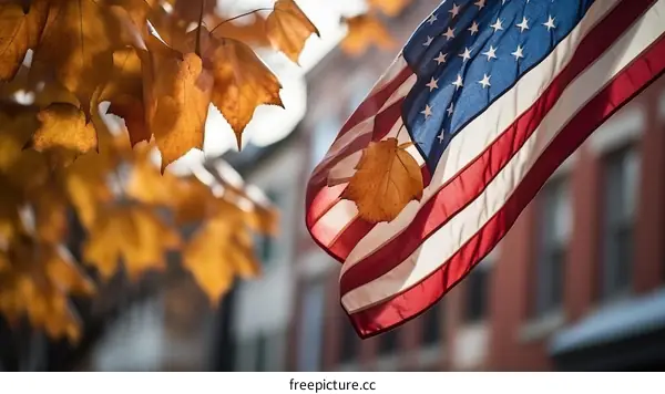 American flag waving in the wind with autumn leaves in the foreground