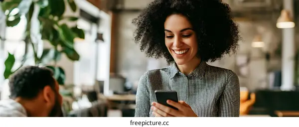 Happy Black Woman Using Smartphone in Modern Office