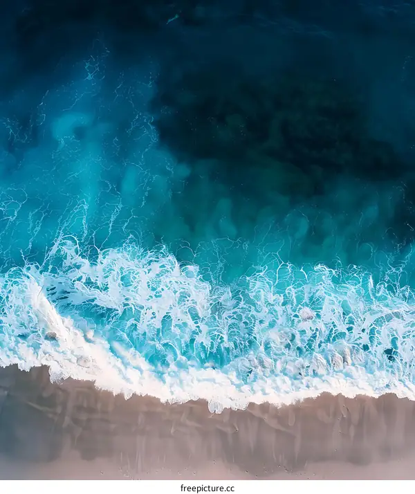 Aerial View Of Blue Ocean Waves Crashing On Sandy Beach