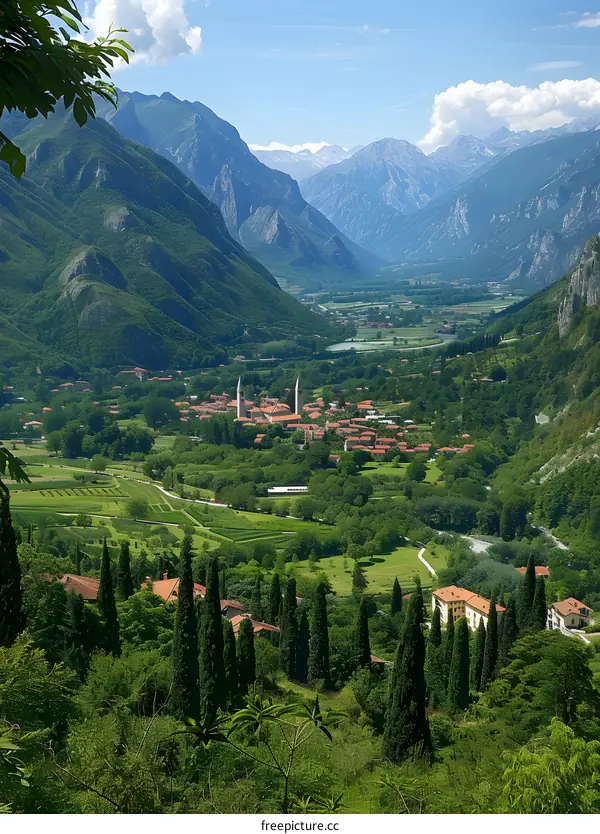 Panoramic View of a Picturesque Mountain Valley with Lush Green Fields and a Charming Village