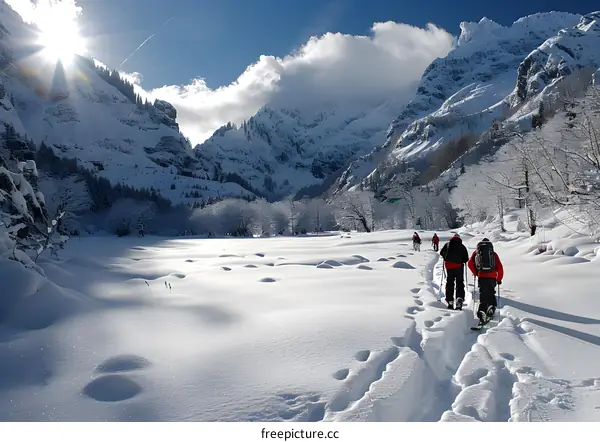 People snowshoeing in a snowy valley