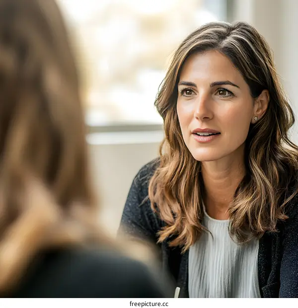 Woman Listening Attentively to Another Woman During a Conversation