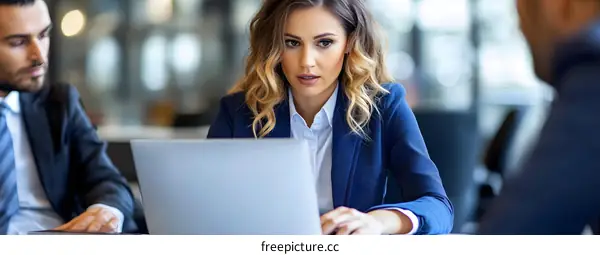 Businesswoman Working on Laptop with Colleague in Office