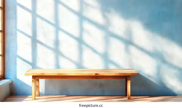Wooden Bench Against Light Blue Wall with Sunlight Shadows