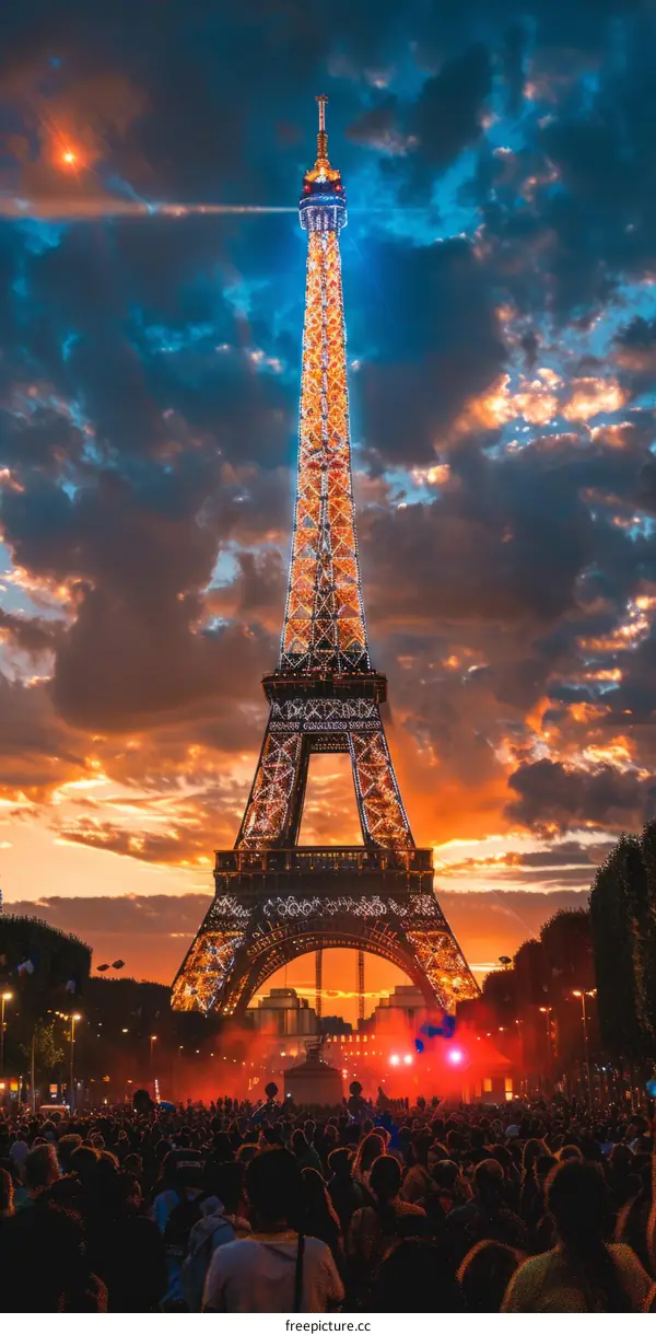 The Eiffel Tower at sunset with a crowd of people in the foreground