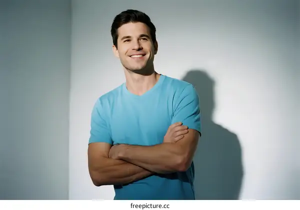 Confident man in light blue t-shirt with arms crossed