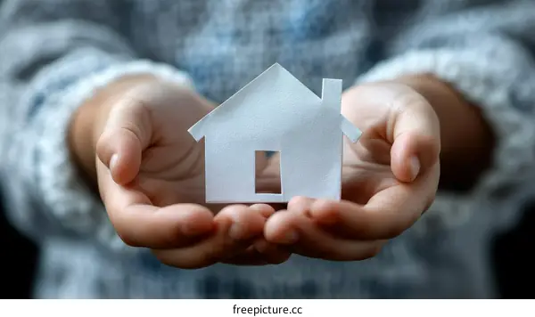 Hands Holding a Paper House Illustrating Homeownership