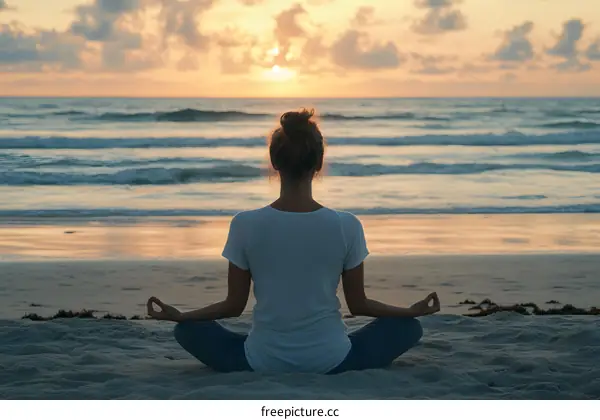 Woman Meditating on the Beach at Sunset