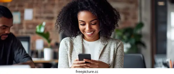 Smiling African American Woman Using Smartphone in Office