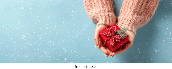 Woman Holding a Red Gift Box with Festive Ribbon