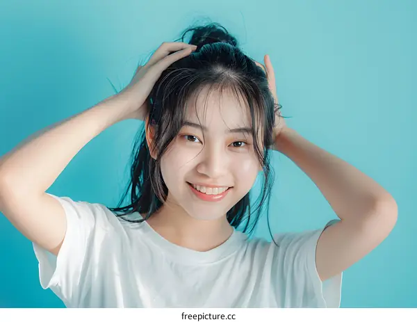 Young Asian Woman Smiling with Hands on Her Head