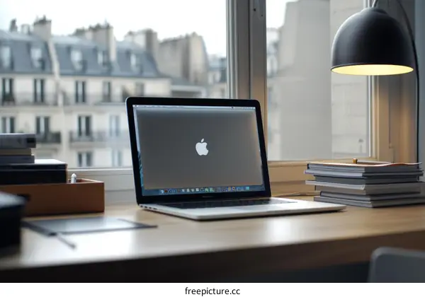 A desk with a laptop, books, and a lamp
