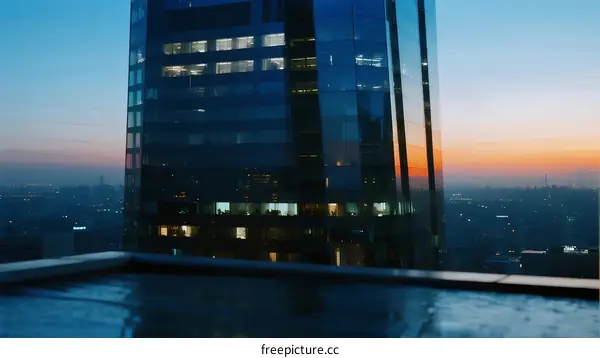 Modern Skyscraper with Glowing Windows at Sunset