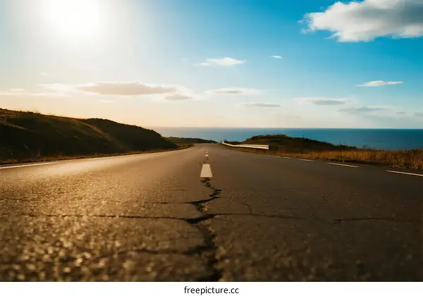 A scenic road leading to the sea under a clear sky