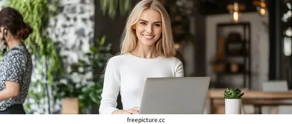 Smiling Businesswoman Working on Laptop in Modern Office