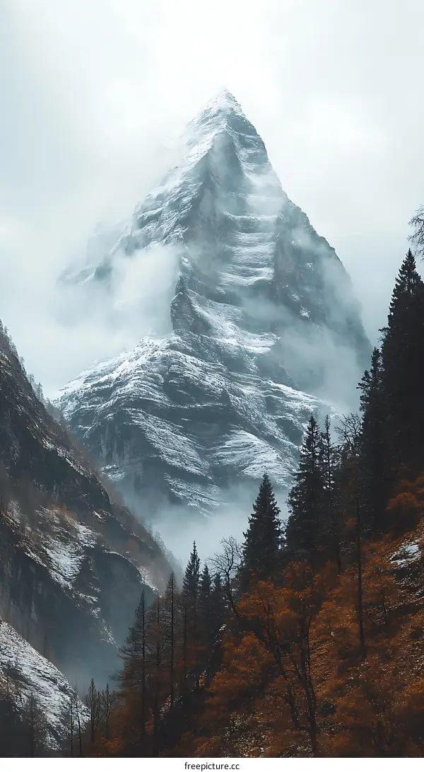 Snowy Mountain Peak Emerging Through Mist And Fog