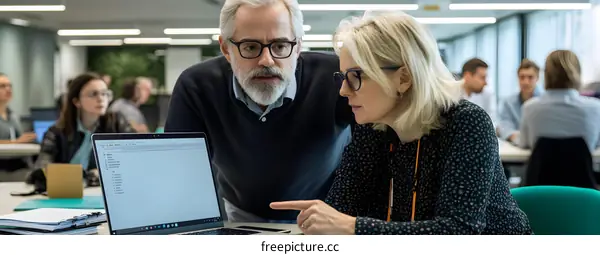 Two Businesspeople Collaborating on a Laptop in an Office Setting