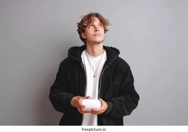 Stylish Caucasian Male Holding Wireless Earbuds