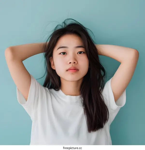 Portrait of a Young Asian Woman with Hands Behind Her Head