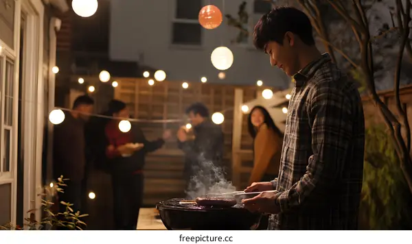 Man Grilling Meat At Backyard Barbeque Party With Friends