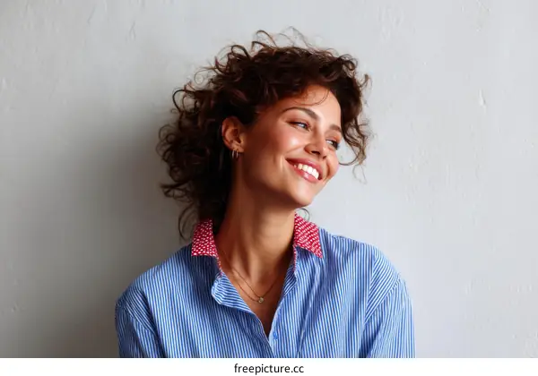 Smiling Woman with Curly Hair in a Striped Shirt