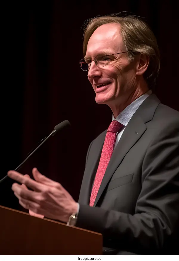 Man in Suit Speaking at Podium with Microphone