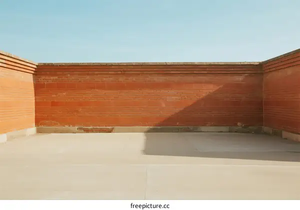 Empty Red Brick Wall and Paved Floor Under Clear Sky