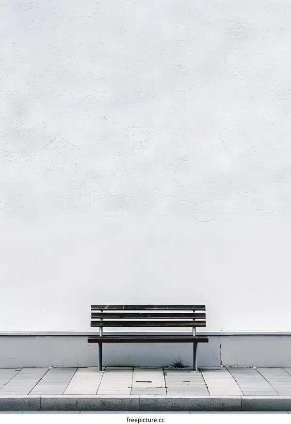Empty Bench Against a White Wall