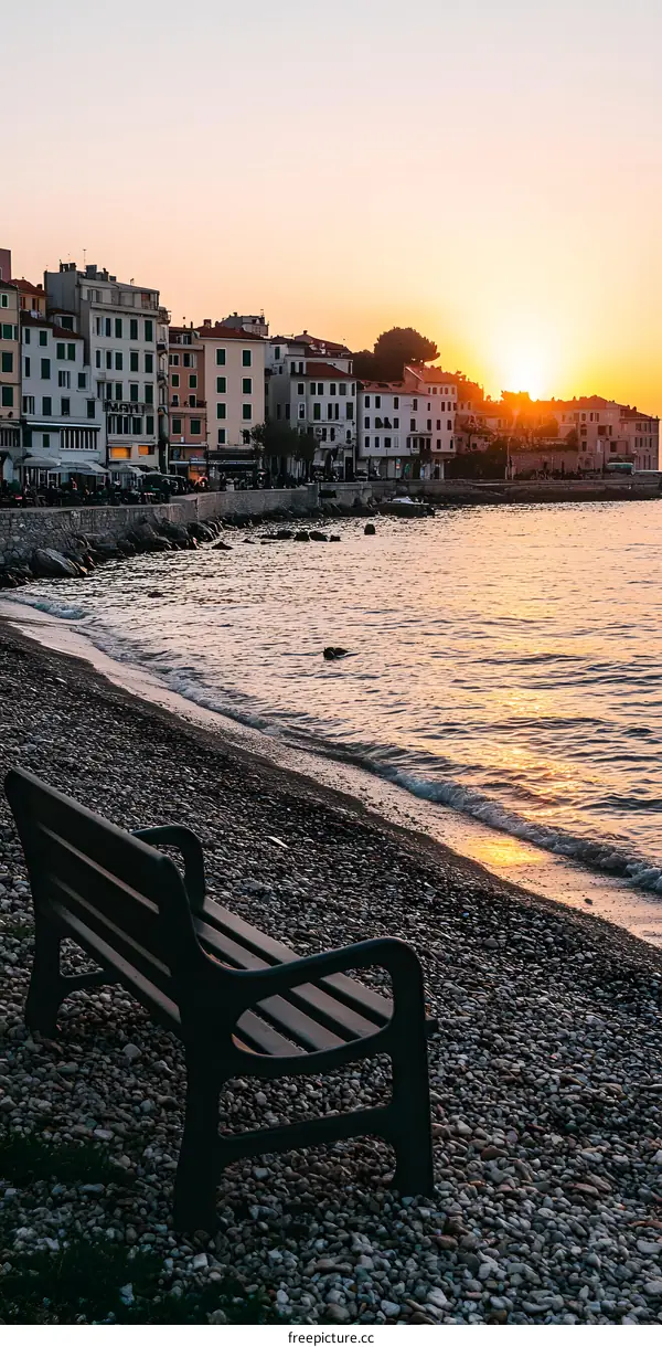 Lonely Bench on a Pebble Beach at Sunset