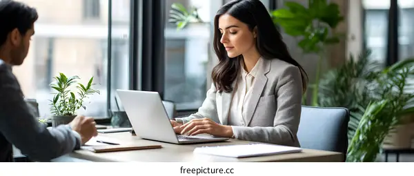 Businesswoman working on laptop in office setting