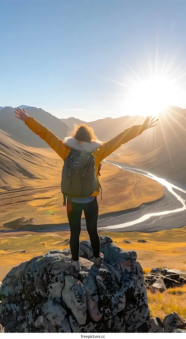 Woman standing on a mountain top with arms outstretched