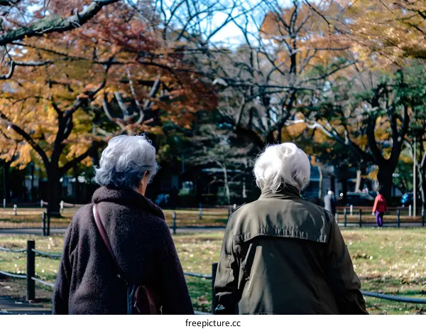 Two Elderly Women Walking in Autumn Park