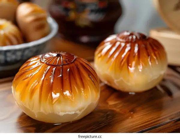 Close Up of Two Golden Brown Glazed Buns on Wooden Board