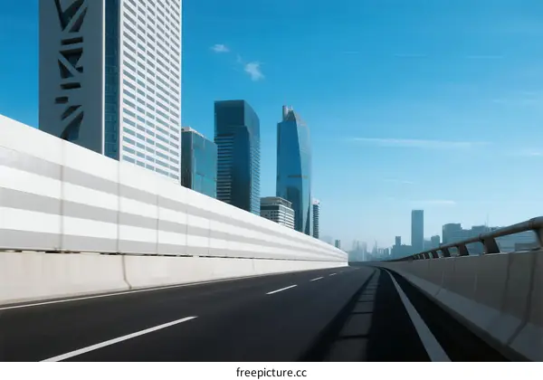 Modern city road with tall buildings under clear blue sky