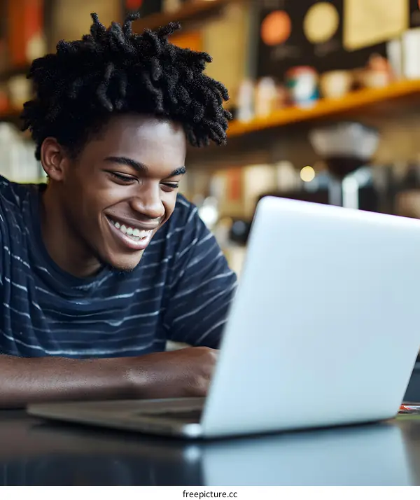 Happy African American Man Using Laptop In Cafe