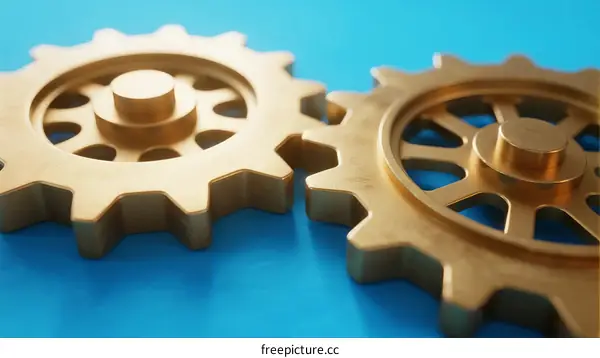 Two golden gears interlocking on blue background showing mechanical interaction
