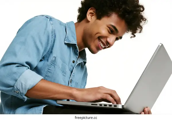 Young man using a laptop with a happy expression
