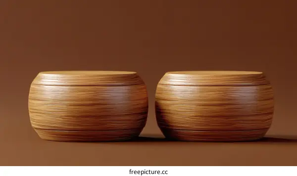 Two Wooden Cylindrical Display Stands on Brown Background