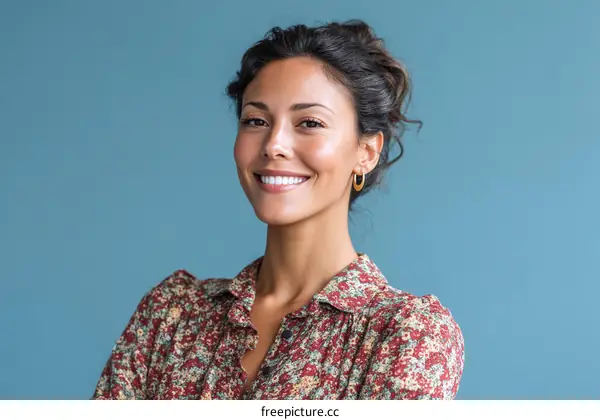 Smiling Woman in a Floral Print Dress against a Blue Background