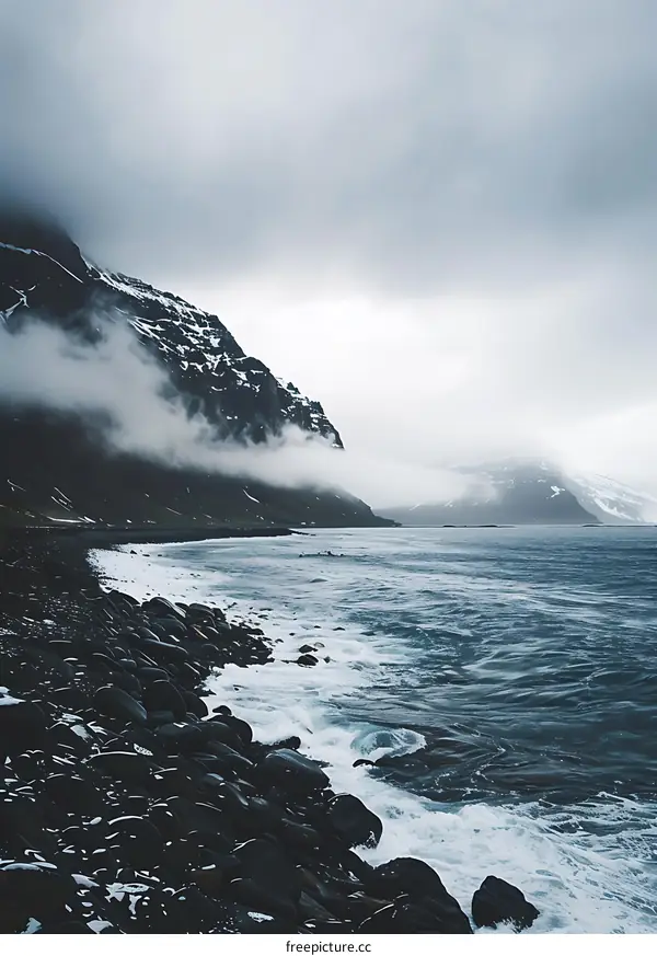 Rocky Beach With Cloudy Sky and Mountain in Background