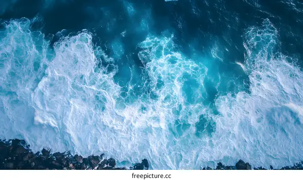 Aerial View of Ocean Waves Breaking on Rocks