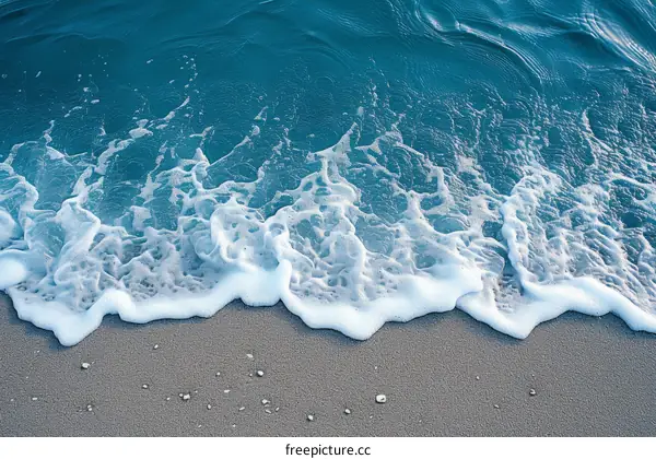 Blue ocean waves crashing on a sandy beach
